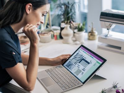 Businessperson holding a Surface Pen and working with a Surface Pro