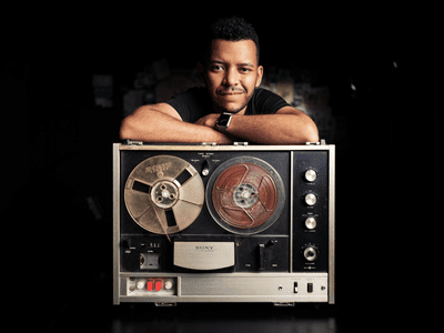 Slidebean founder Jose Cayasso leaning on an old Sony reel to reel tape recorder