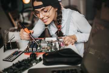 Woman working on a computer motherboard.