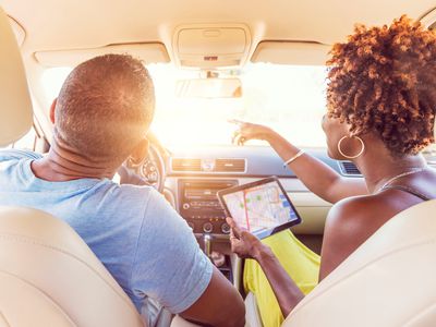 Couple in car using ipad with navigation