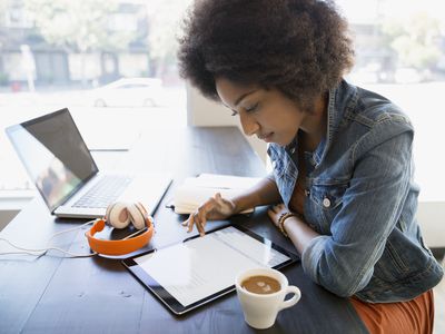 Focused remote worker working at digital tablet in cafe