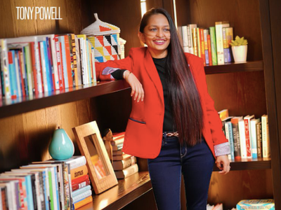 Shavini Fernando with her arm resting on a bookshelf