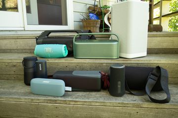 Group of waterproof speakers on wooden steps.