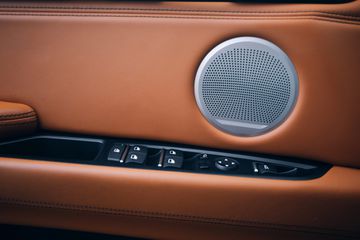 Close-up of round speaker mounted on a car door