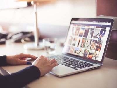 A stock photo of a person browsing the internet on a laptop.