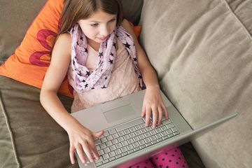 Young girl using laptop on sofa