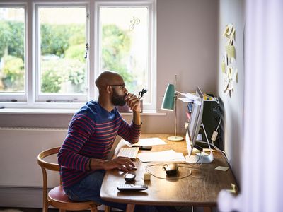 Man in striped shirt sitting at his desk and working on his computer