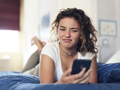 A woman looking skeptically at her phone