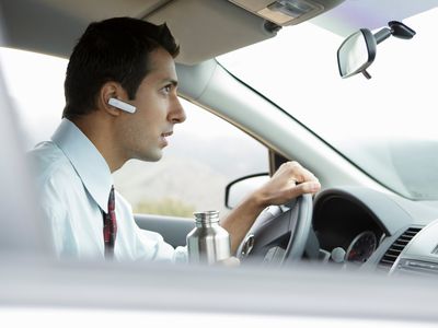 Man in car with bluetooth earpiece