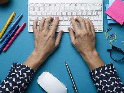 Wireless keyboard and mouse on a table with office supplies