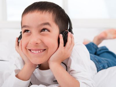 Boy laying down listing to headphones