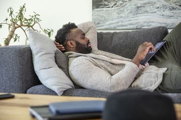 Man on couch with tablet.