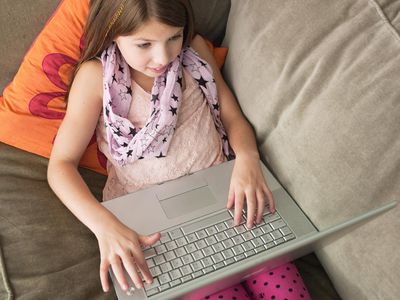 Young girl using laptop on sofa