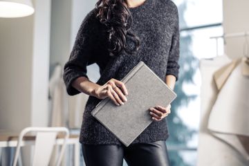 A woman holding a Surface Pro 7 with a Type Cover.