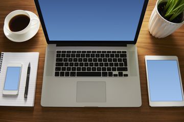 An image of various gadgets sitting on a computer desk.