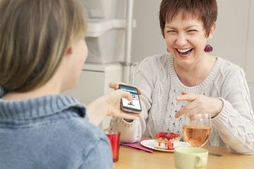 A mother hands her child a phone after setting Amazon parental controls.