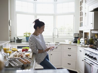 Blogger using an iPad in a kitchen while cooking