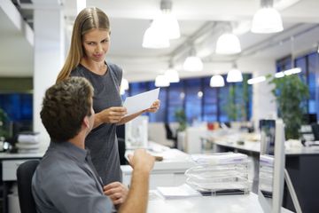 Coworkers discussing printed page