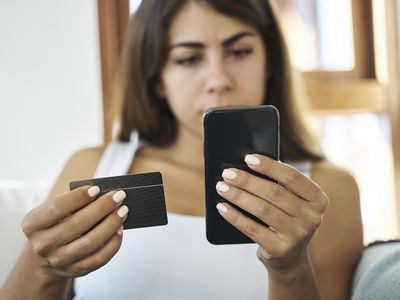 Woman Looking at Business Card and Phone