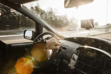 A woman listens to her ipod in her car with an FM transmitter