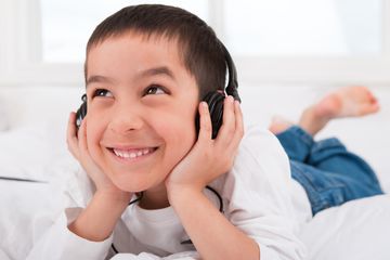 Boy laying down listing to headphones