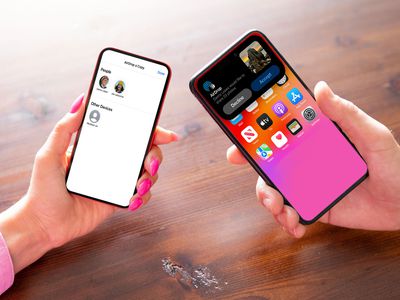 Two people holding phones over a wooden table. The AirDrop interface is open on both