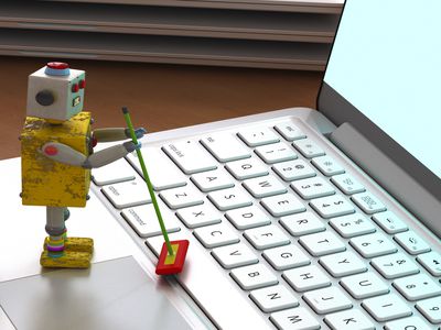 Tiny robot with mop and cleaner pretending to clean a laptop.