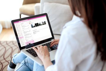 A woman accessing Outlook emails on her laptop computer.