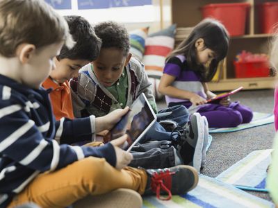 Kids in a classroom using tablets.