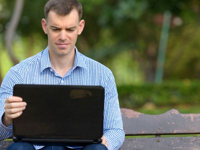 A businessman trying to use a webcam on his Windows 10 laptop.