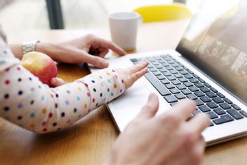 Infant using computer with parent's supervision