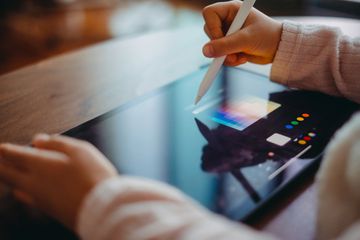 Closeup on someone drawing on a tablet computer using a stylus pen.