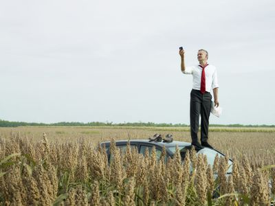 A man trying to find a signal for iPhone Emergency Roadside Assistance