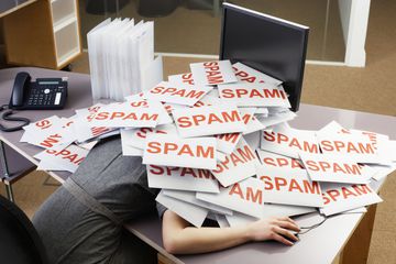 Person under a pile of Spam mail