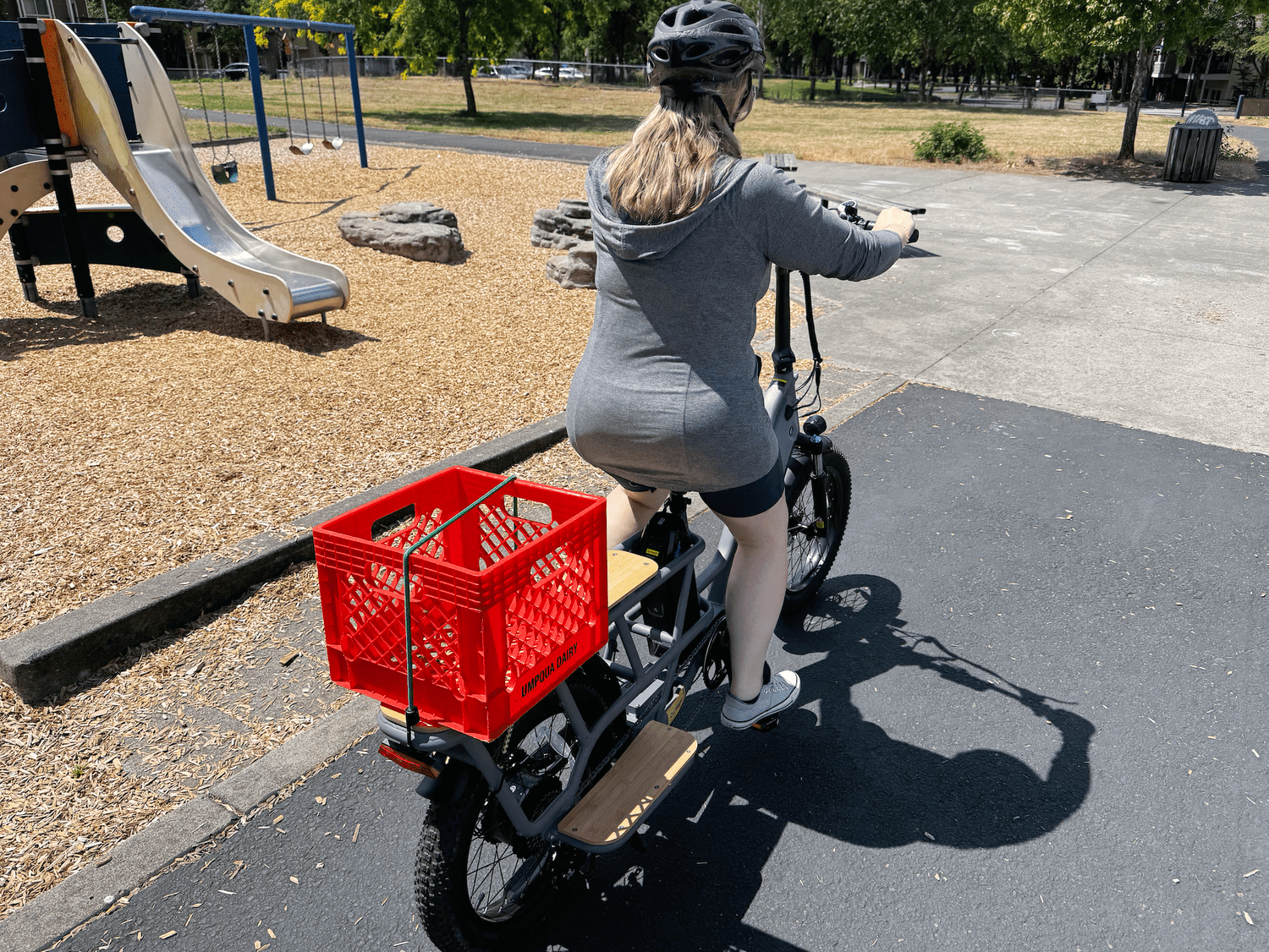 CycWagen with rider and milkcrate on cargo board at playground