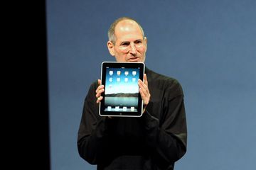 Steve Jobs holding up the original iPad in 2010