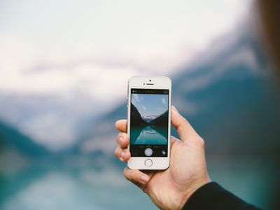 A person holding up an iPhone while taking a picture.