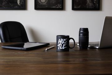 Desk with laptop, tablet, camera and coffee cup