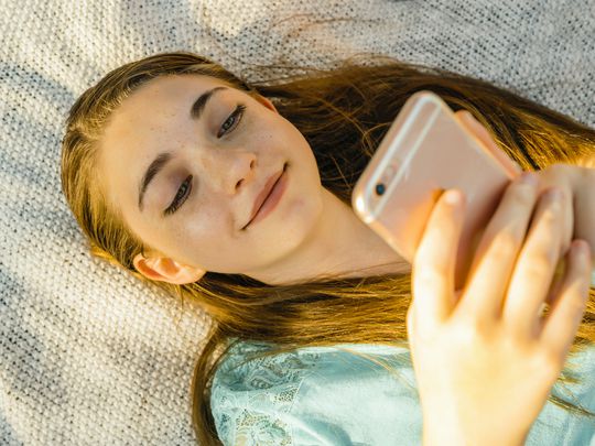 A teenage girl looking at her smartphone.