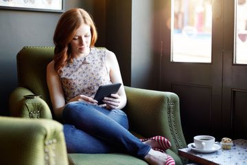 Woman using an e-reader to read a public domain book found online