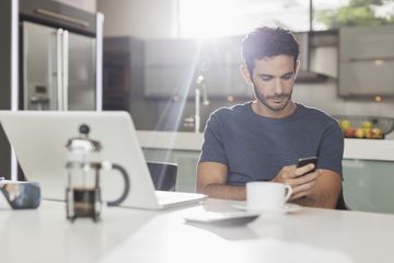 Person using an iPhone in a sunny kitchen