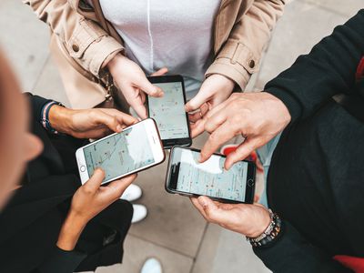 Three people looking at map apps on their smartphones.