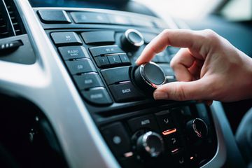 Closeup of person turning a radio volume dial