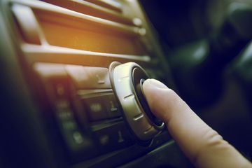 Person fiddling with a car radio