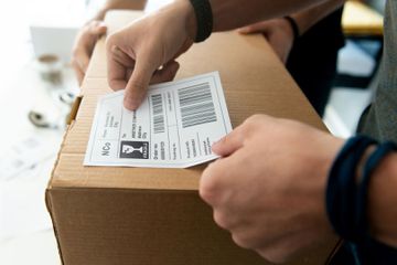 A man sticking his own barcode sticker onto a box