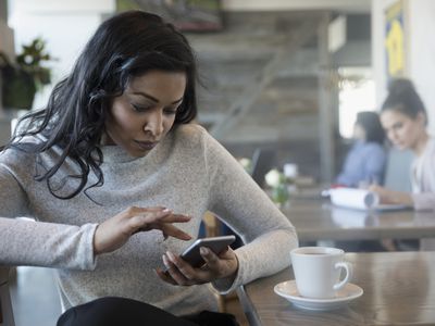 Woman in cafe using her iPhone