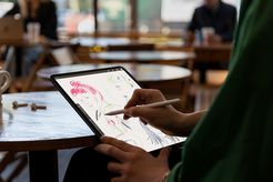 A man sketching on an iPad Pro using an Apple Pencil