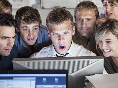 coworkers looking at something shocking on computer