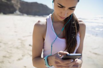 Woman using her phone on the beach