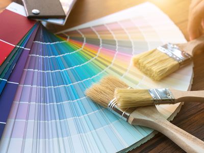 Paint chips and paint brushes are spread out on a table.